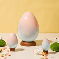 Milk chocolate easter eggs in baby pink and baby blue with mini rainbow marshmallows and little bunny figurines all around